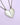 Two heart-shaped necklaces with split in the middle, one in silver color and the other in gold, each with a personalized inscription.