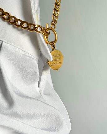 Gold chain with a tag on a white background