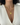 Gold chain necklace with a round pendant on a white fabric background